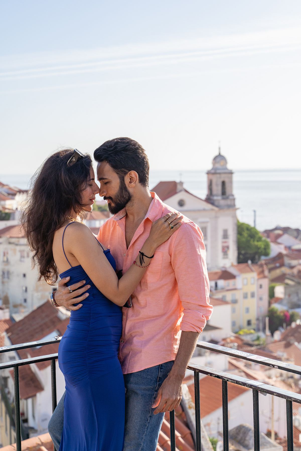 Couple kissing at a Lisbon viewpoint overlooking Alfama