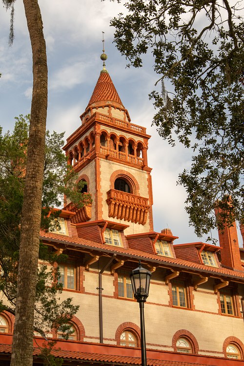 Red-tiled Spanish Renaissance tower spire glowing at sunrise at Flagler College in St. Augustine, Florida.