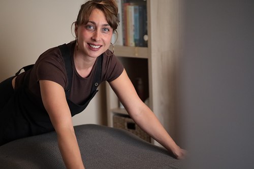 Elisabeth souriante préparant sa cabine de massage.