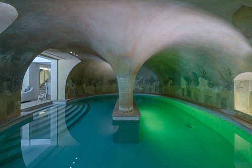 Piscine intérieure à Saint-Germain-des-Prés sous grandes voûtes en pierre avec colonnes et fresques murales. Photographie d'architecture intérieure par Nicolas Karadimos.