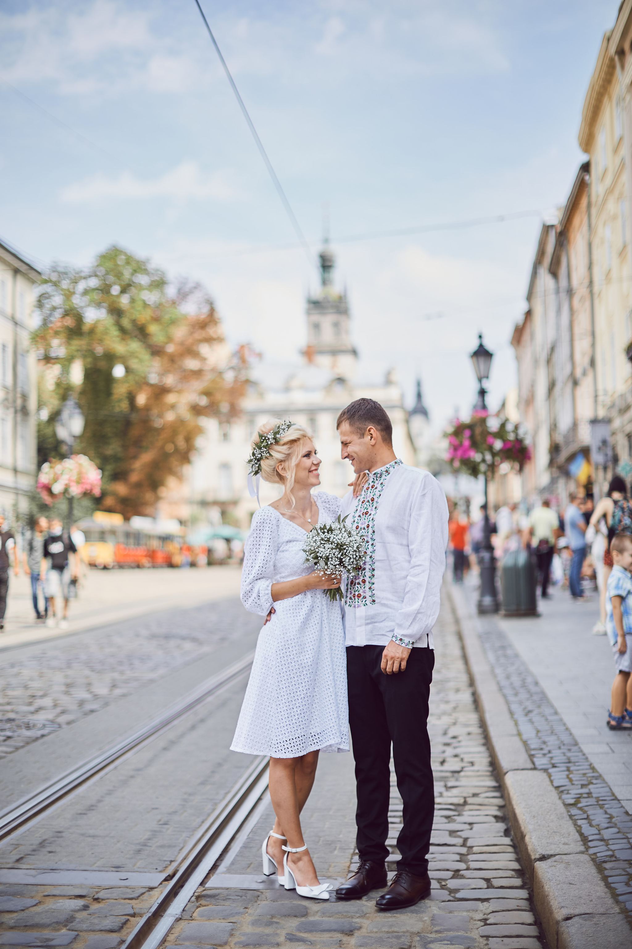 Bride and groom standing together on a busy city