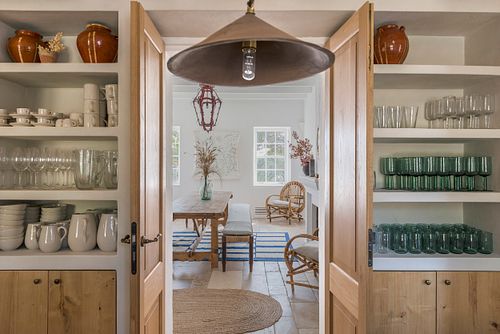 Vue à travers des portes ouvertes vers la salle à manger de la finca d’agrotourisme à Santa Ponça, Minorque. Photographie par Nicolas Karadimos.