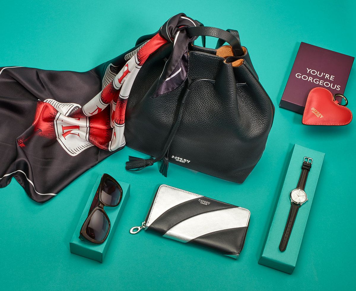 green table with black handbag, floral scarf, watch and purse