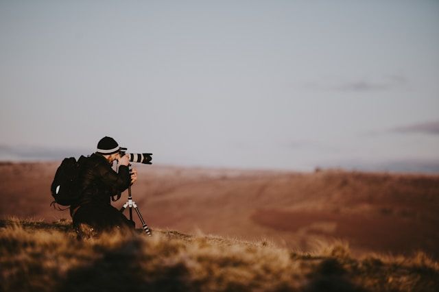 Immagine di un fotografo che scatta una foto di un paesaggio