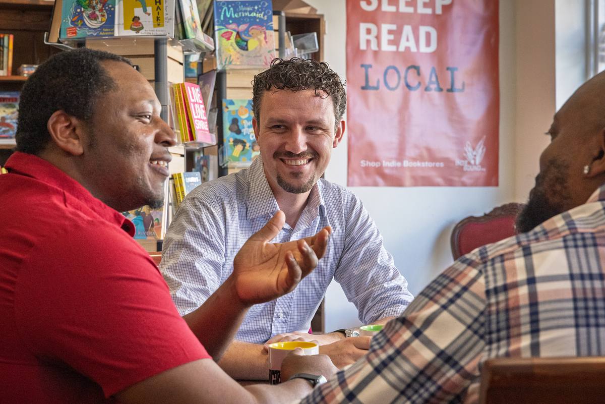 A business owner talks to patrons in a Downtown Durham NC coffee shop