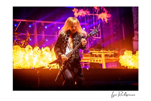 Horizontal color image of Chris Caffery of Trans Siberian Orchestra playing electric guitar on stage with flames and fire effects