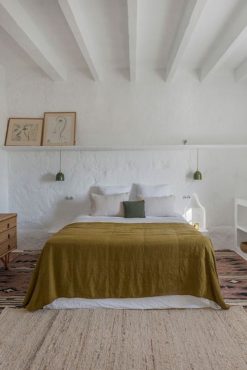 Chambre à coucher lumineuse de la finca d’agrotourisme à Santa Ponça, Minorque, avec lit king size et poutres apparentes au plafond. Photographie par Nicolas Karadimos.