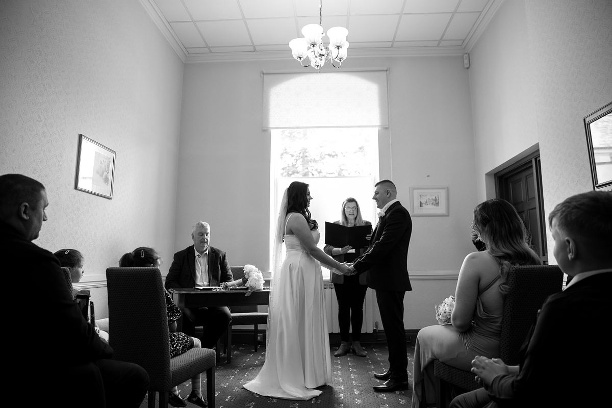 Black and white wedding ceremony at Pontypool Register Office with bride and groom exchanging vows
