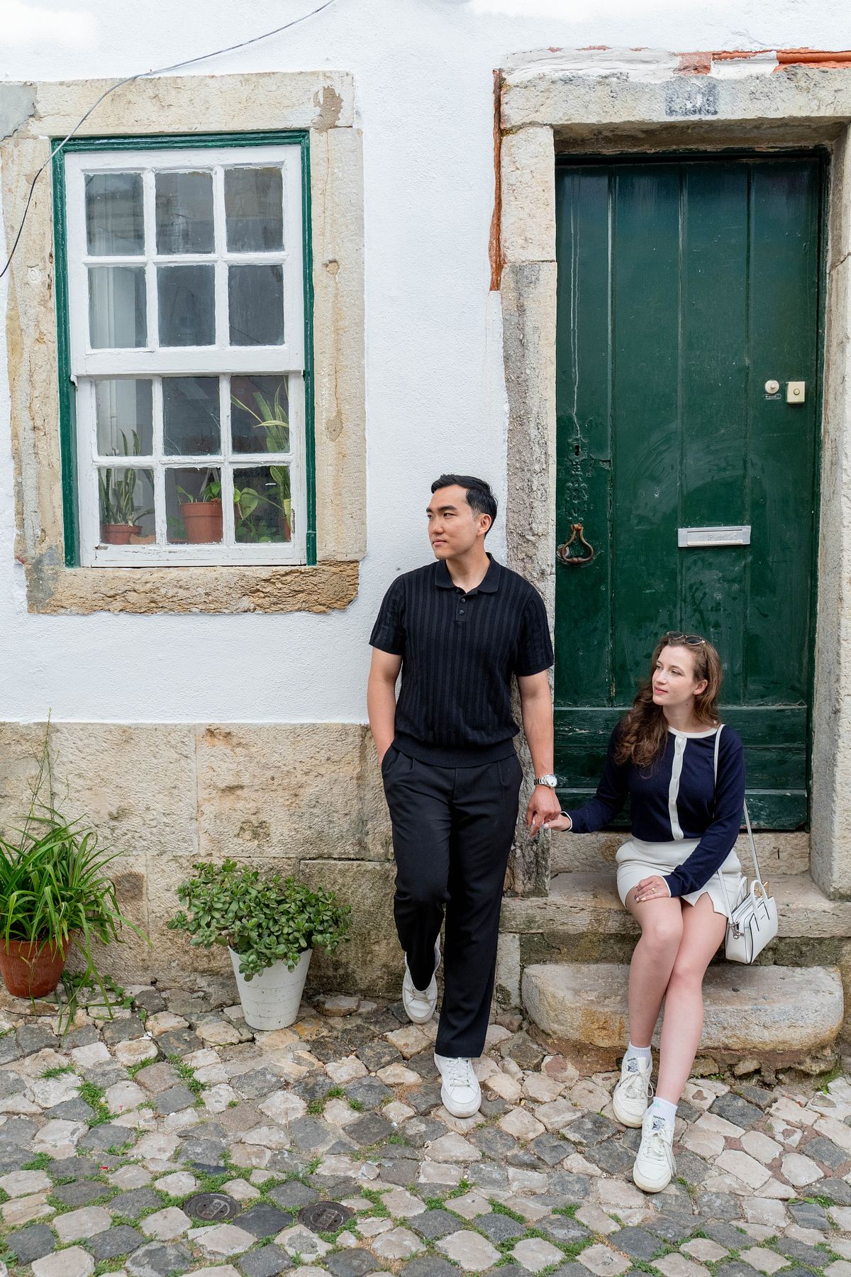 Couple posing outside a green door on a Lisbon street