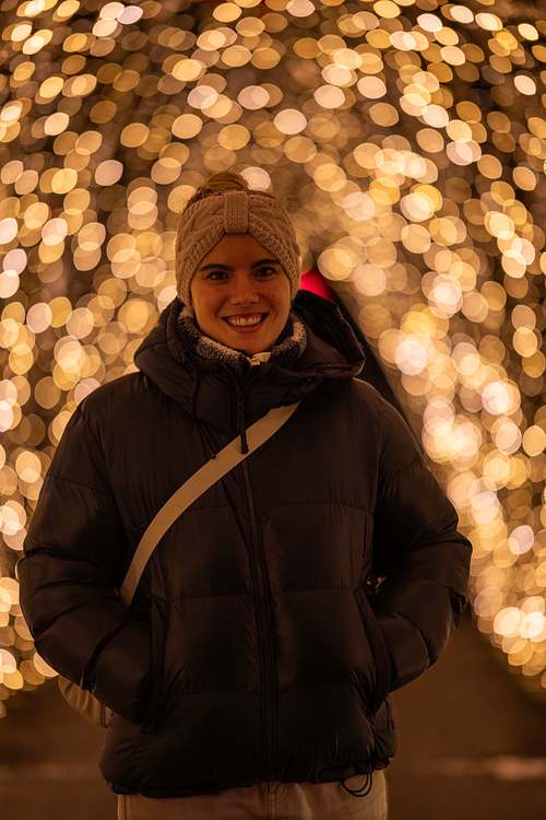 Porträt einer Frau mit Stirnband vor einem Lichterketten-Vorhang