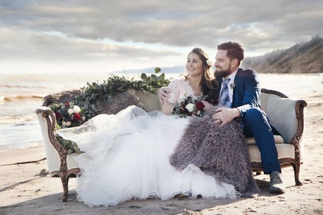mężczyzna i kobieta siedzą na wyściełanej sofie nad morzem