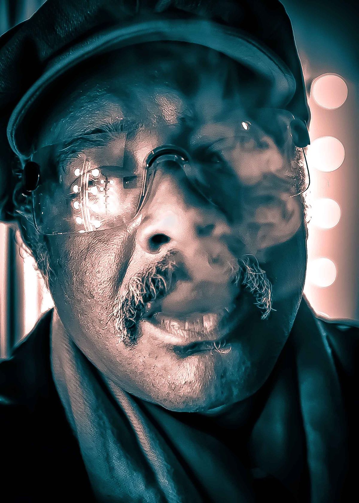 Portrait of a Cuban musician smoking a cigar with smoke filling his face.