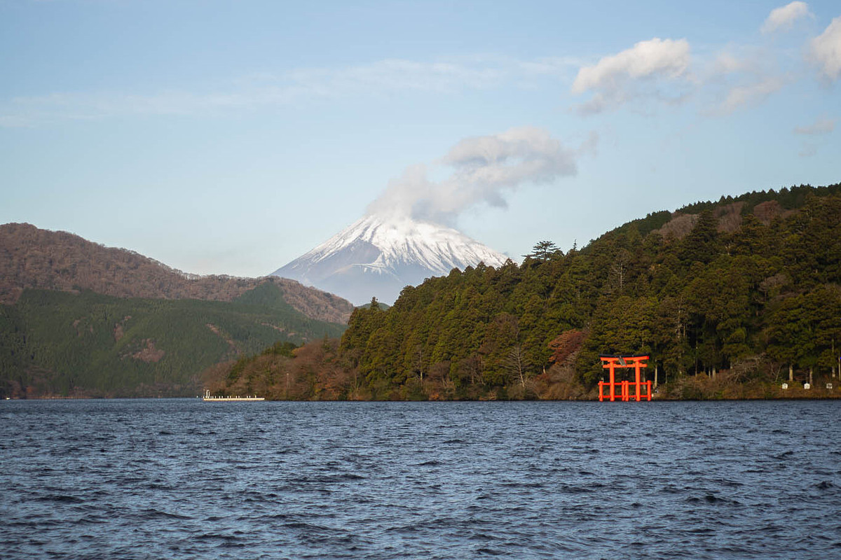 Torii rouge planté dans le lac Ashi à Hakone, reflets au petit matin