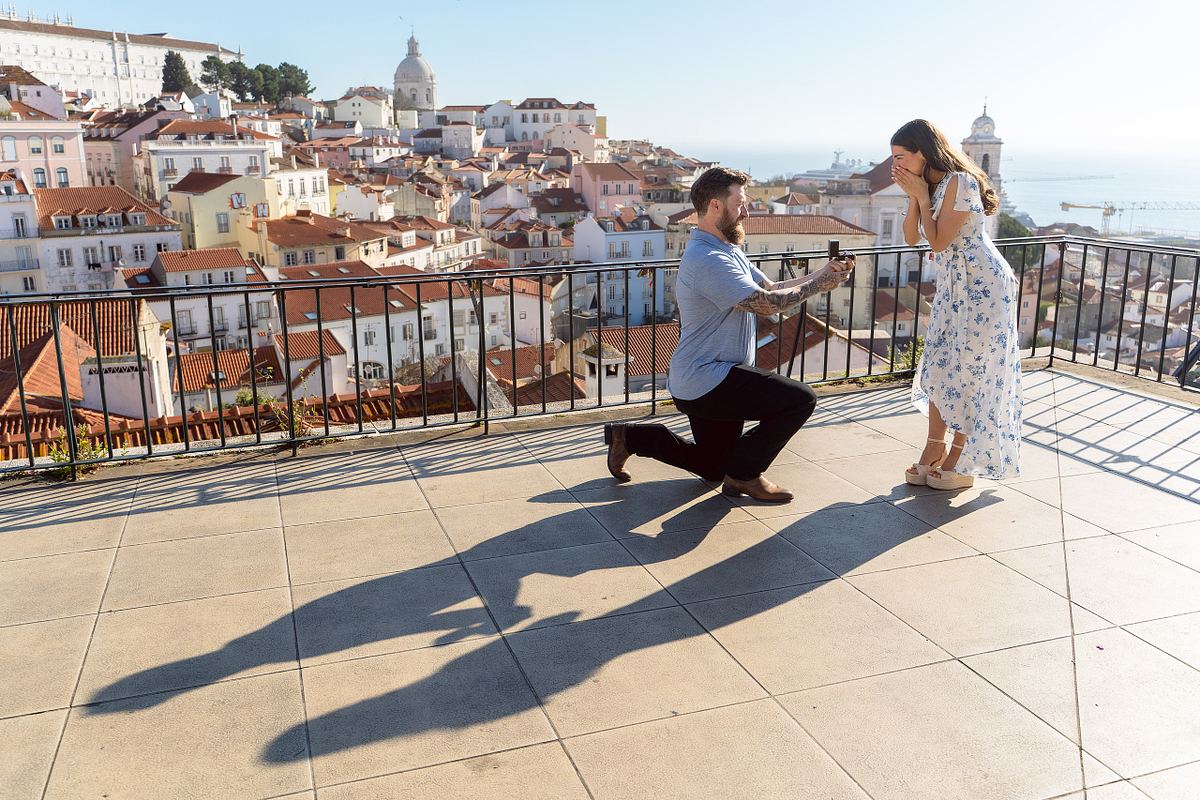 Man proposing to his partner at a viewpoint overlooking Alfama