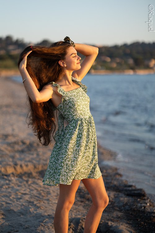 Jeune femme au bord de la mer levant le visage vers le soleil couchant à l’Almanarre