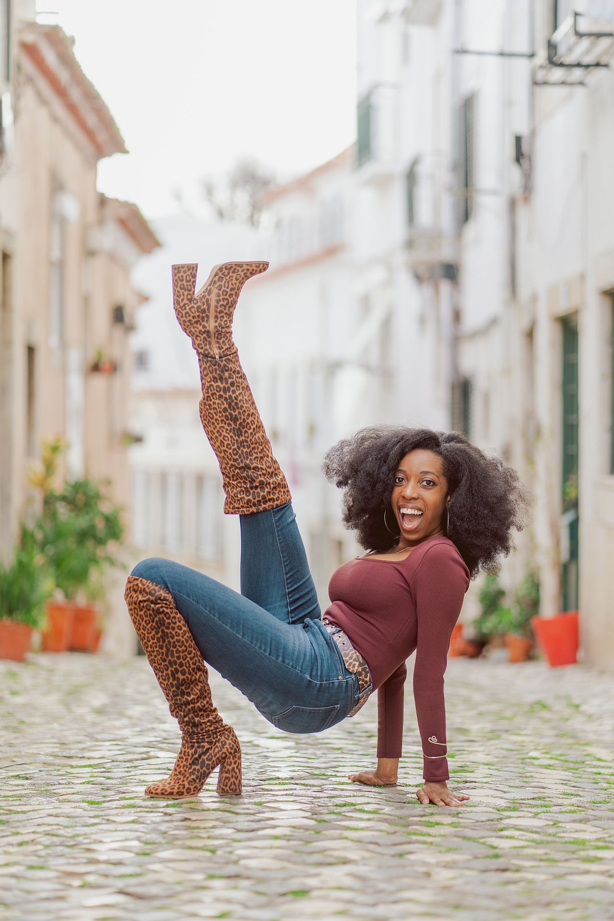 Woman posing in leopard-print boots on a cobbled Lisbon street