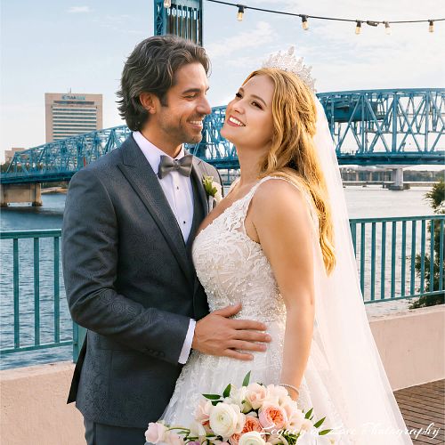 Bride and groom embracing on Main Street Bridge in Downtown Jacksonville overlooking the river