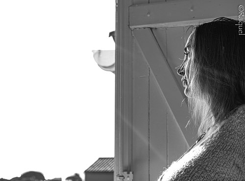 Portrait noir et blanc d'une femme regardant par la fenêtre en lumière naturelle