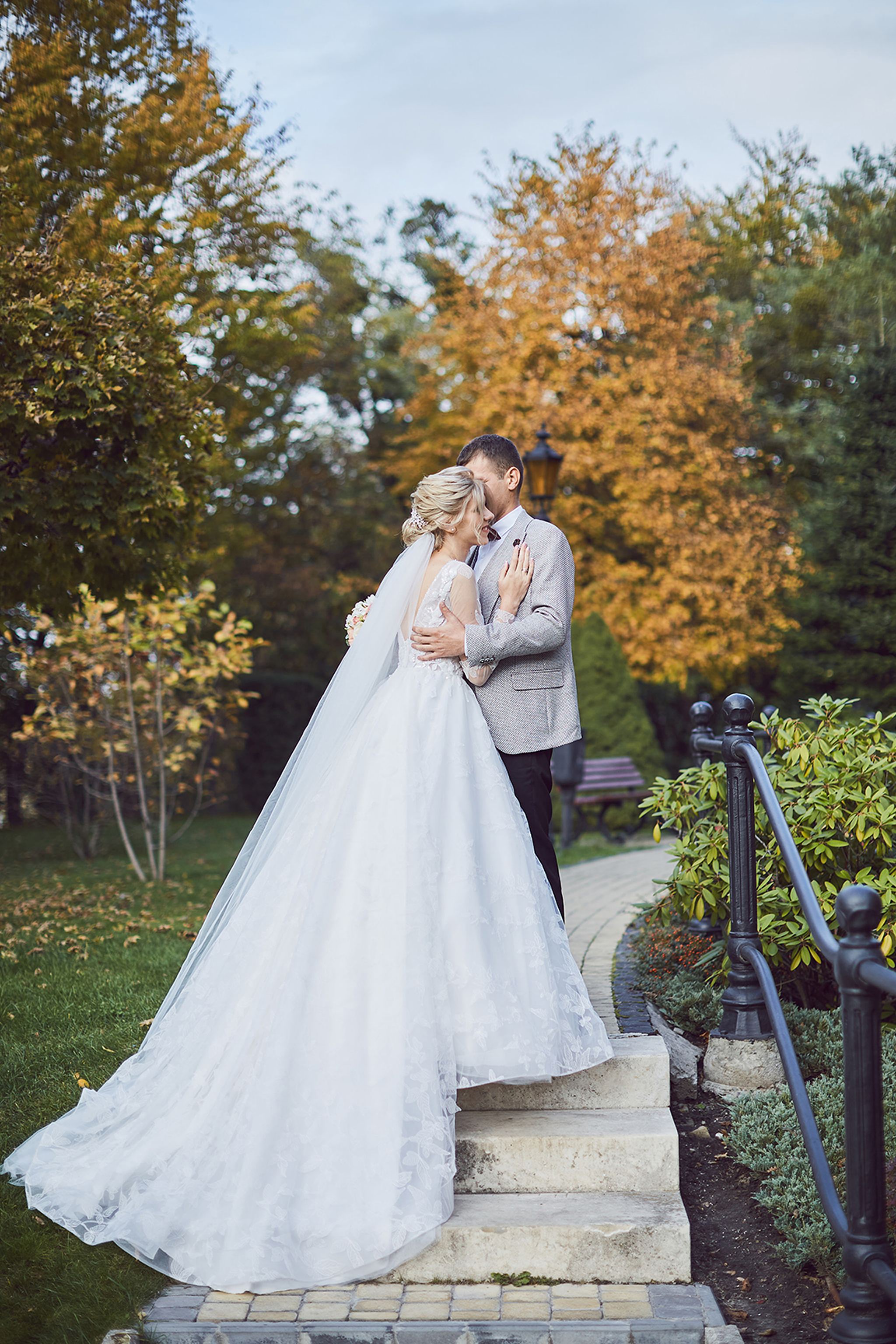 Bride and groom embracing in an autumn garden