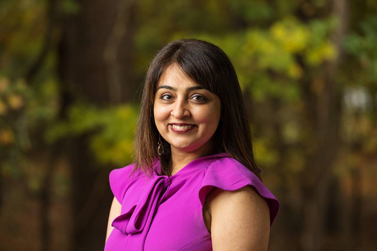 A UNC professor poses for a headshot with a natural background at Dr. Martin Luther King Jr. Park in Carrboro, NC