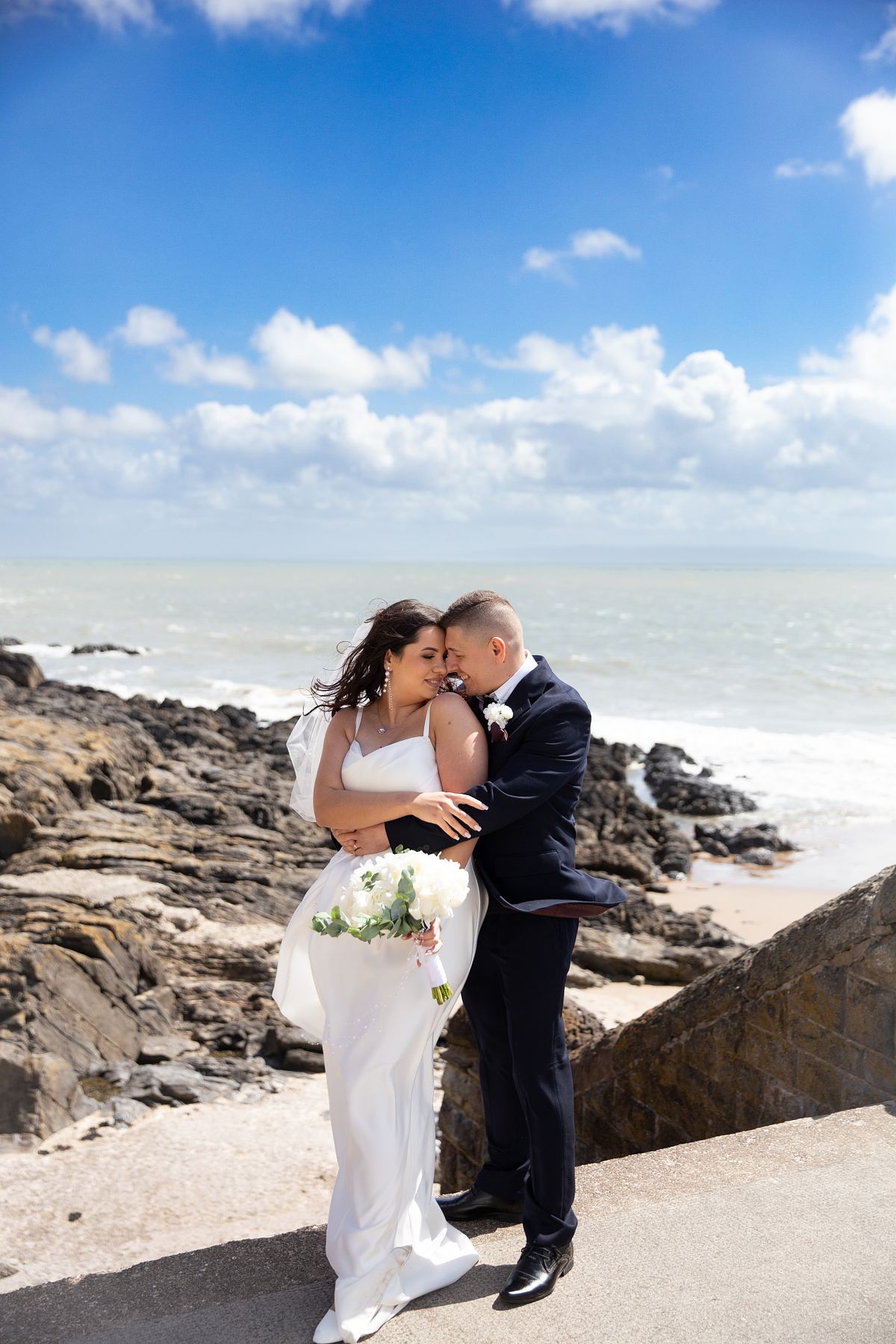Bride and groom by the coast at Barry Island, South Wales