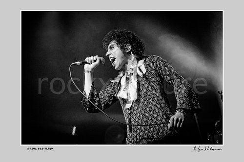 Horizontal black and white image of Greta Van Fleet singer Josh Kiszka singing into a microphone during a live performance