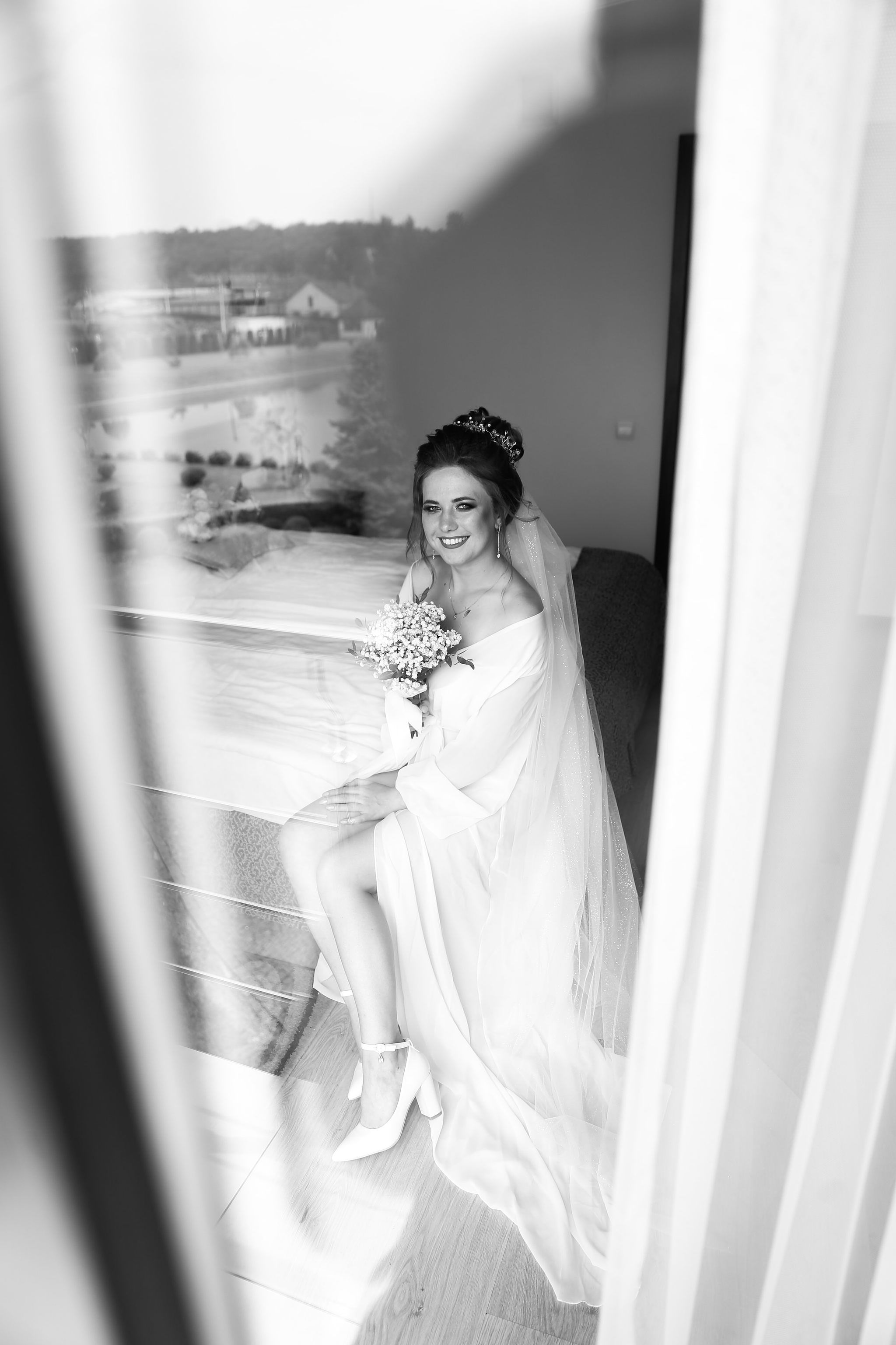 Bride by the window during wedding morning preparations in Ukraine