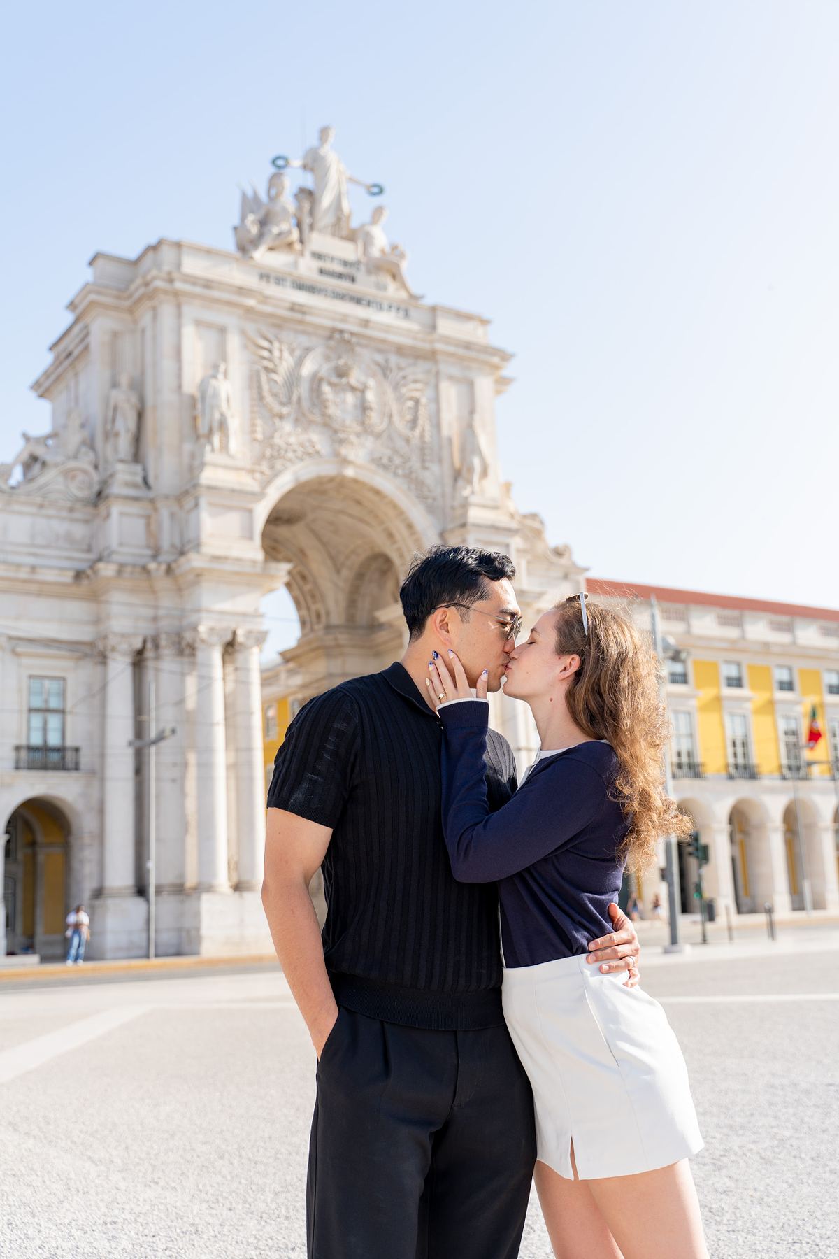 Couple kissing in front of a historic Lisbon square