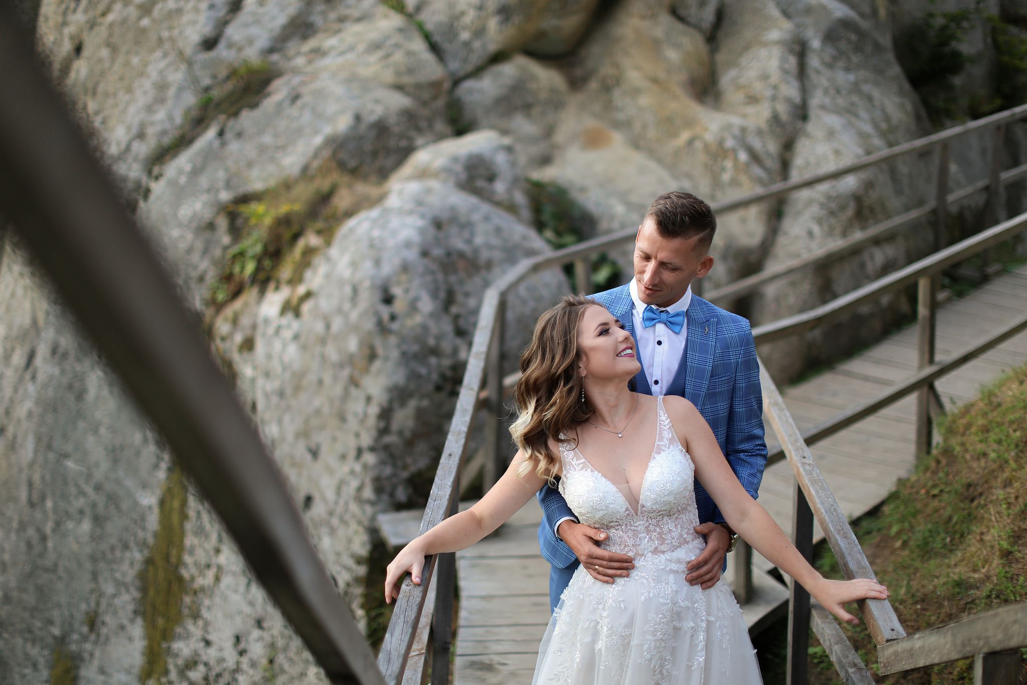 Bride and groom walking through the wooden bridge at Tustan Fortress, Ukraine