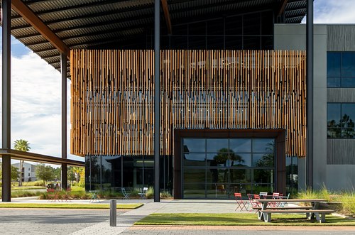 Facade of Rayonier Forestry Headquarters featuring vertical timber screen elements and outdoor seating under a deep roof overhang