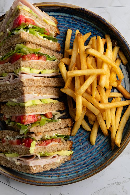 Club sandwich con papas en cafetería en Panamá