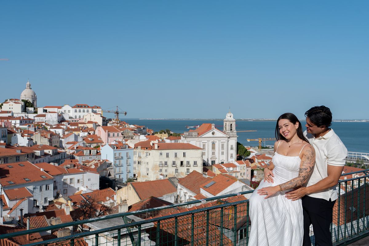 Newly engaged couple celebrating with Alfama and the Tagus River behind them