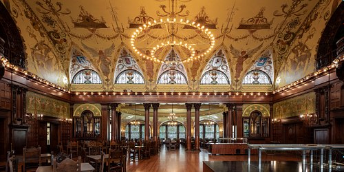 Grand Dining Hall at Flagler College with Tiffany stained glass, George W. Maynard murals, and a chandelier.