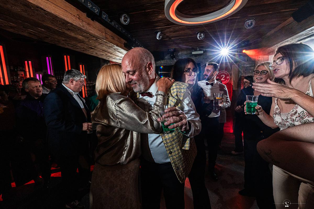 Cocktail et Soir&eacute;e de Mariage avec les invit&eacute;s et les mari&eacute;s qui s'amusent, sourient, s'embrassent et dansent. Les Rhodos La Clusaz Sebastien Clavel Photographe Mariage Lyon