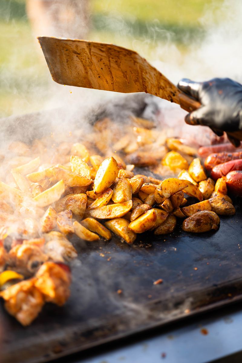 Ziemniaki i kiełbaski na grillu podczas imprezy plenerowej