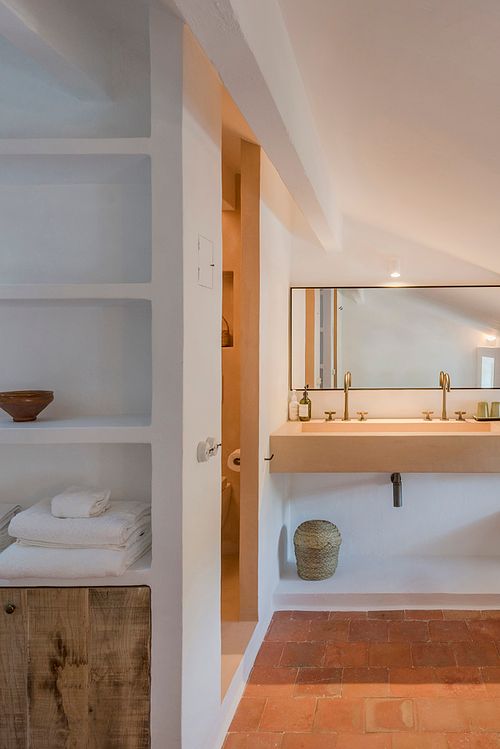 Salle de bains de la finca d’agrotourisme à Santa Ponça, Minorque, avec double vasque en bois et grand miroir. Photographie par Nicolas Karadimos.
