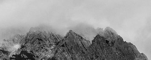Rocky mountain ridge in black and white under moving clouds – fine art landscape photography