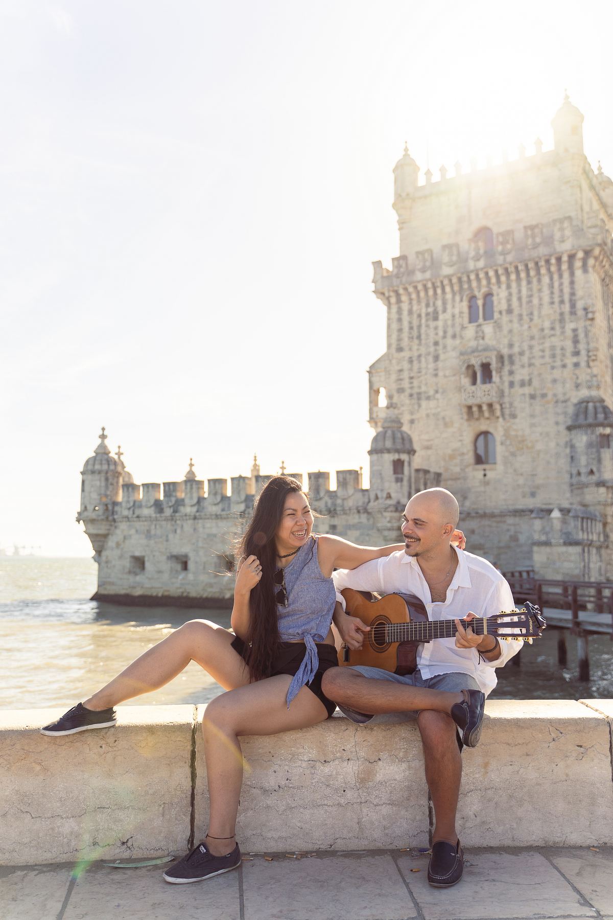 Couple sitting together beside a historic Lisbon tower