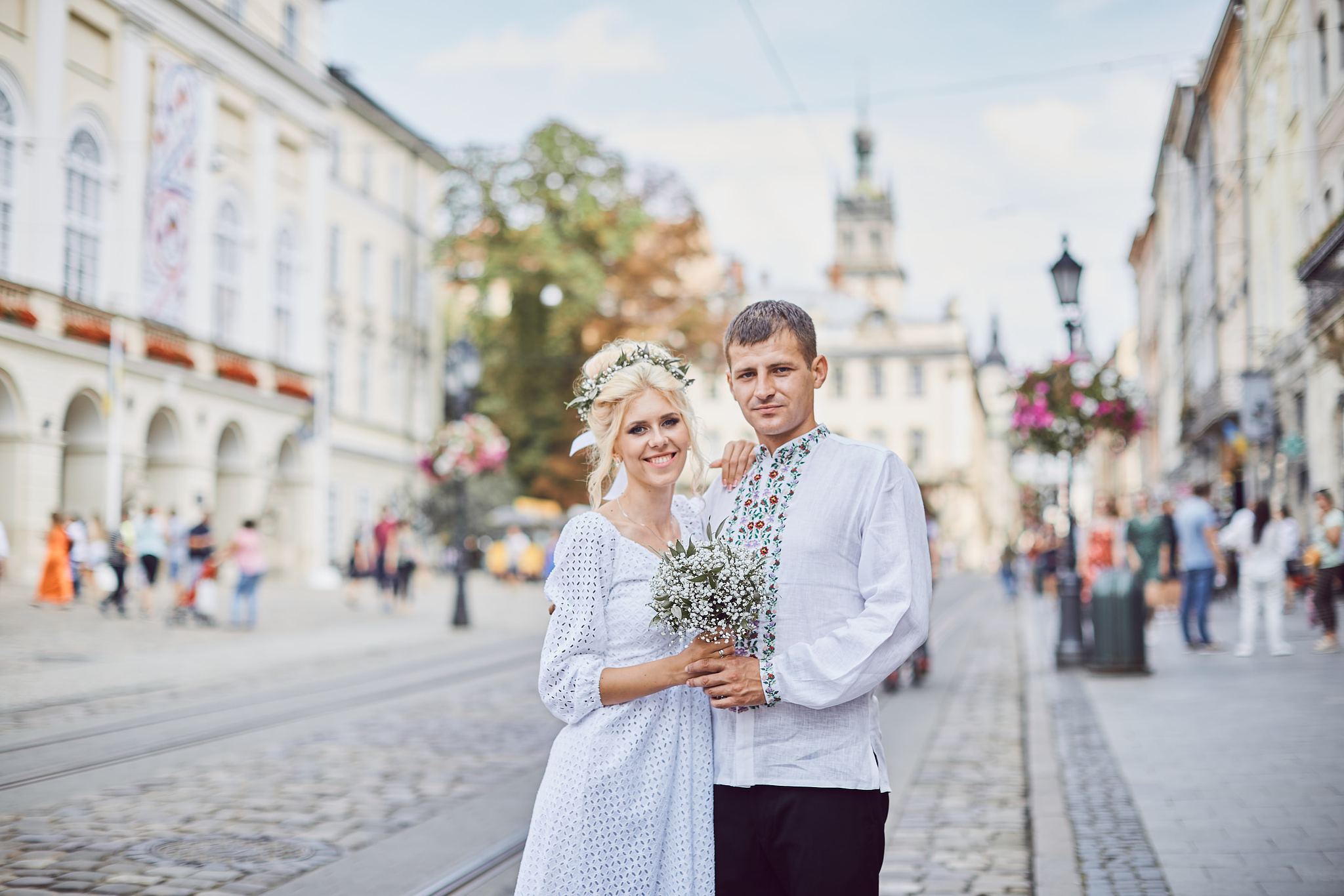Bride and groom standing together on a busy city street