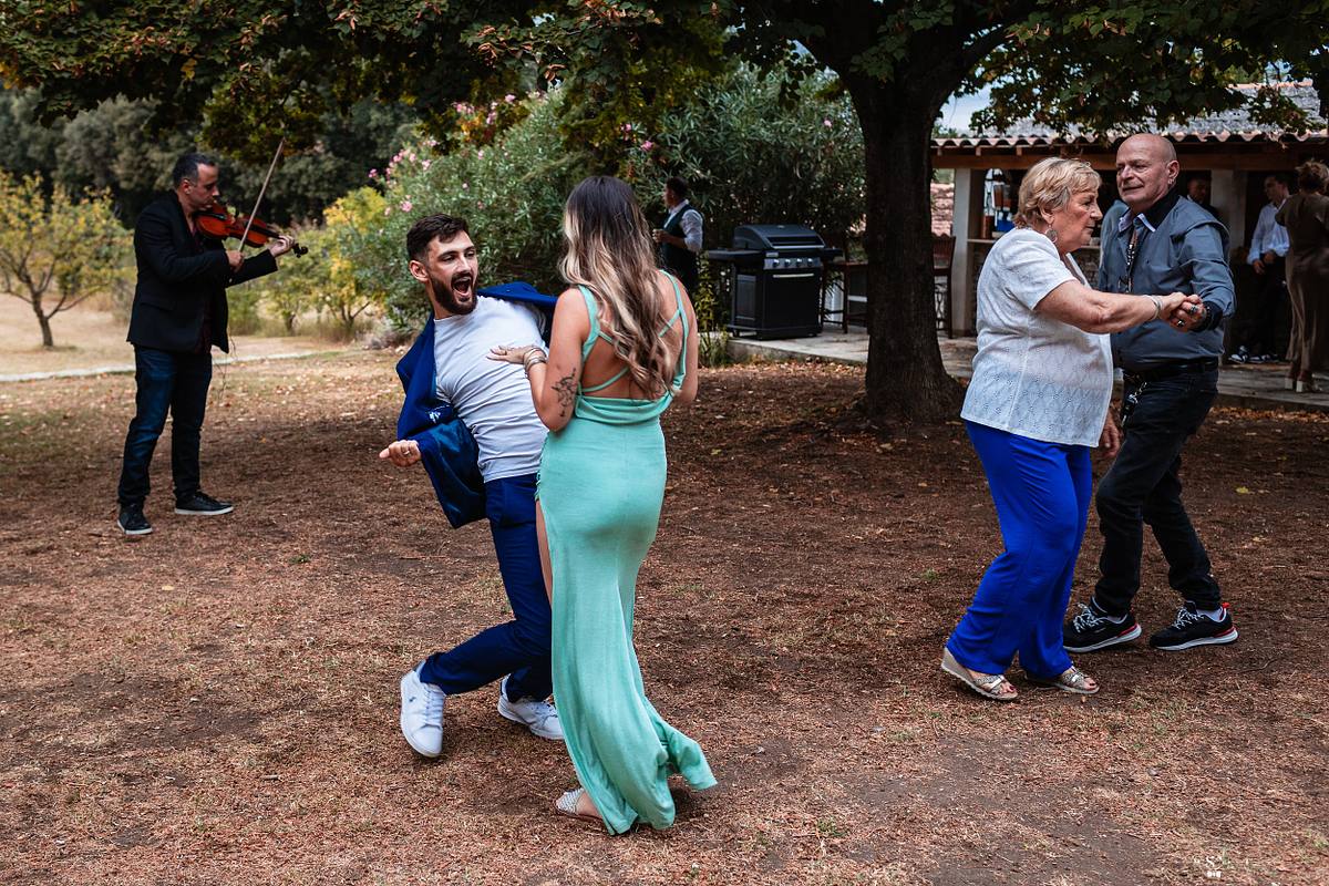 Couple dansant avec joie sur une piste ext&eacute;rieure, anim&eacute;e par un violoniste, immortalis&eacute; par S&eacute;bastien Clavel, photographe de mariage lyonnais