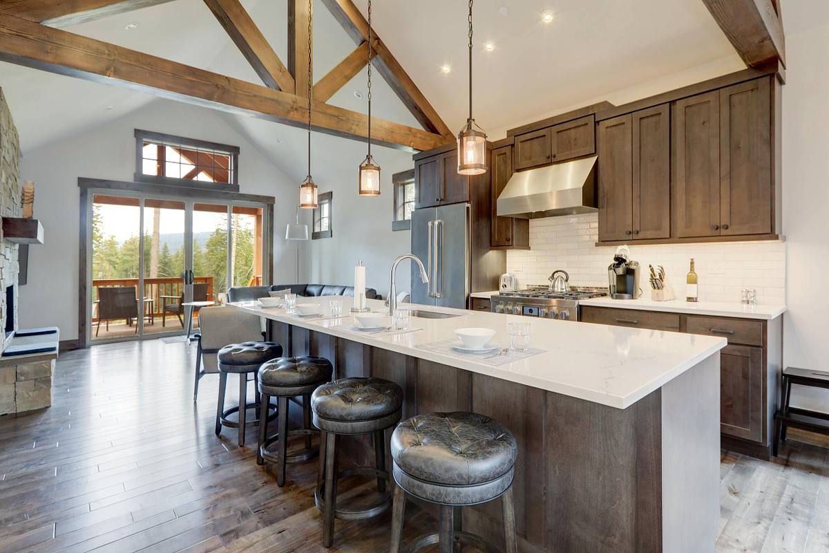 Amazing modern and rustic luxury kitchen with vaulted ceiling and wooden beams, long island with white quarts countertop.