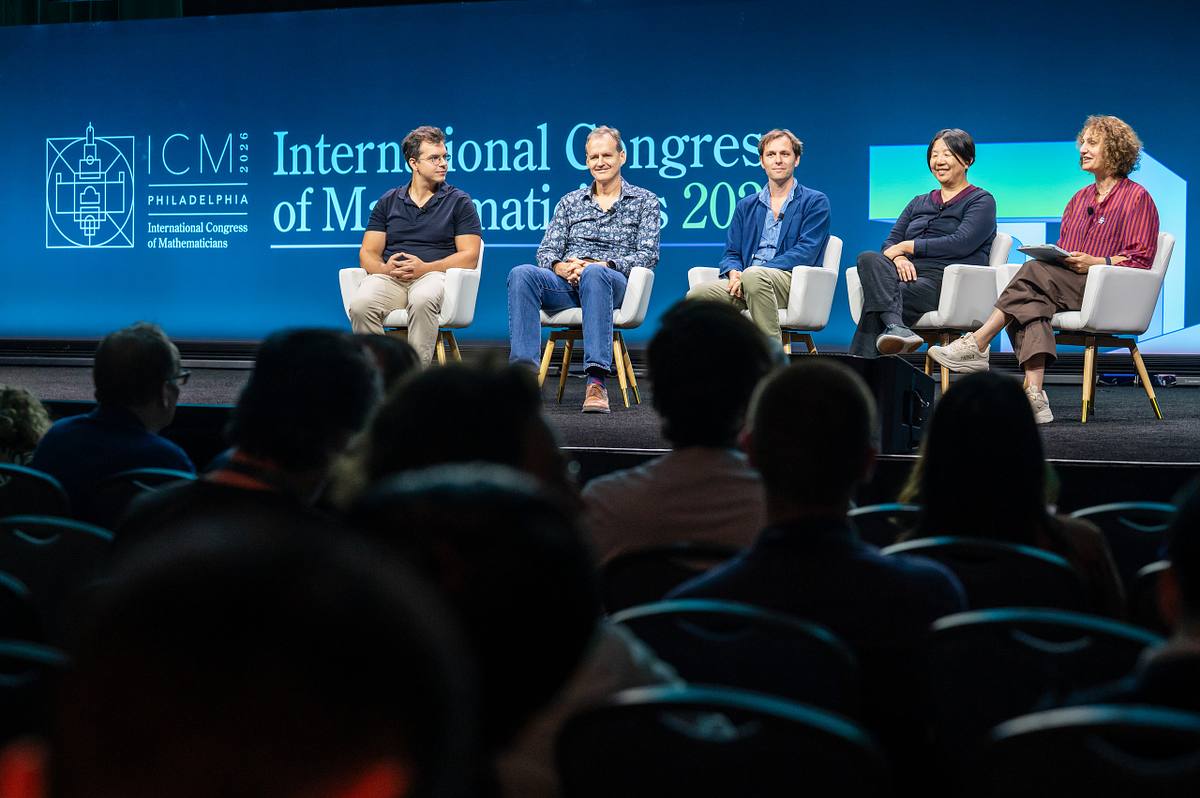 Five panelists sit onstage before an audience at the International Congress of Mathematicians 2026 in Philadelphia.