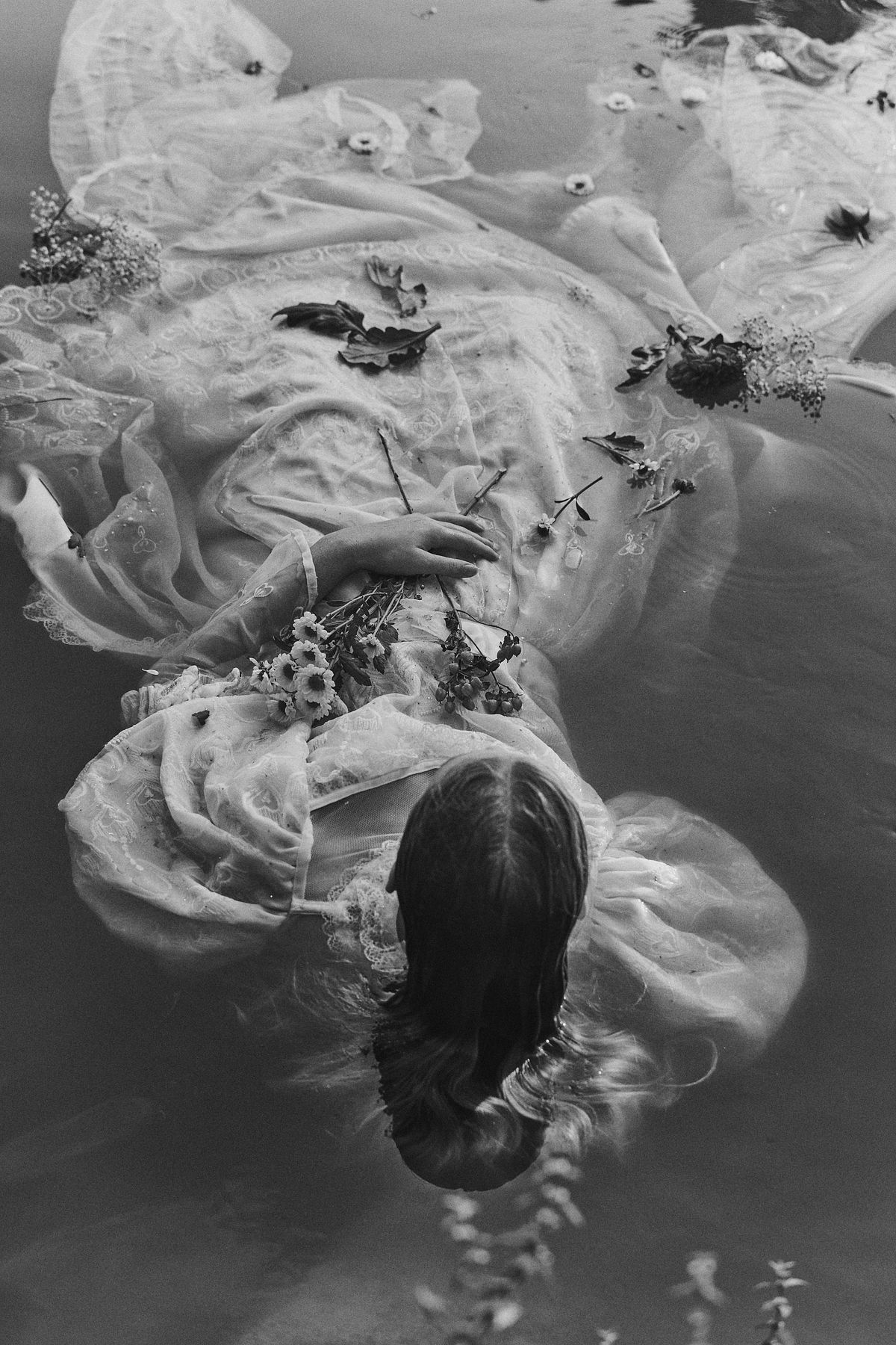Reinterpretation of Ophelia drowning surrounded by flowers, poetic fine art photography inspired by Millais, by Gabriel Matula.
