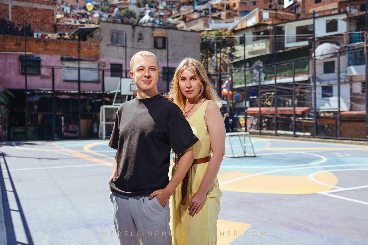 Couple standing on the painted basketball court in Comuna 13, Medellin
