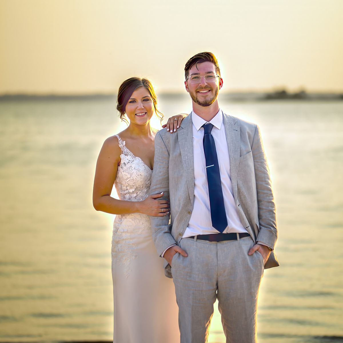 bride and groom standing on the bay side beach at the hyatt in Dewey beach, relaxed and laughing