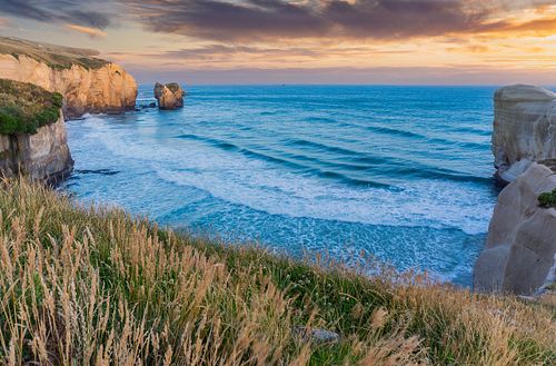 Seascapes, ocean, waves, shores, sand, rocks, surf, clouds, sky, travel, nature, landscape, seaside, beach, Dunedin, Otago, South Island, New Zealand,Tunnel Beach, Brighton, cliffs, hole, sunrise, sunset, grass