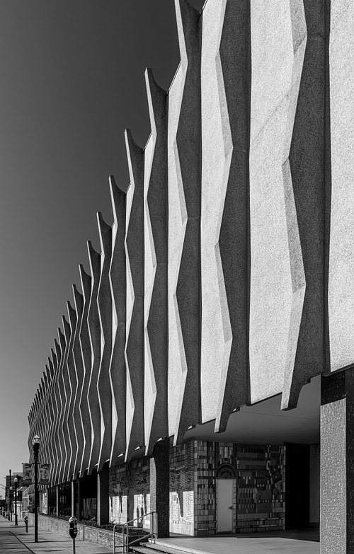High-contrast black and white architectural photograph highlighting the striking vertical fins and dramatic geometric shadows of the historic Jessie Ball duPont Center in Jacksonville, Florida, designed by Taylor Hardwick.