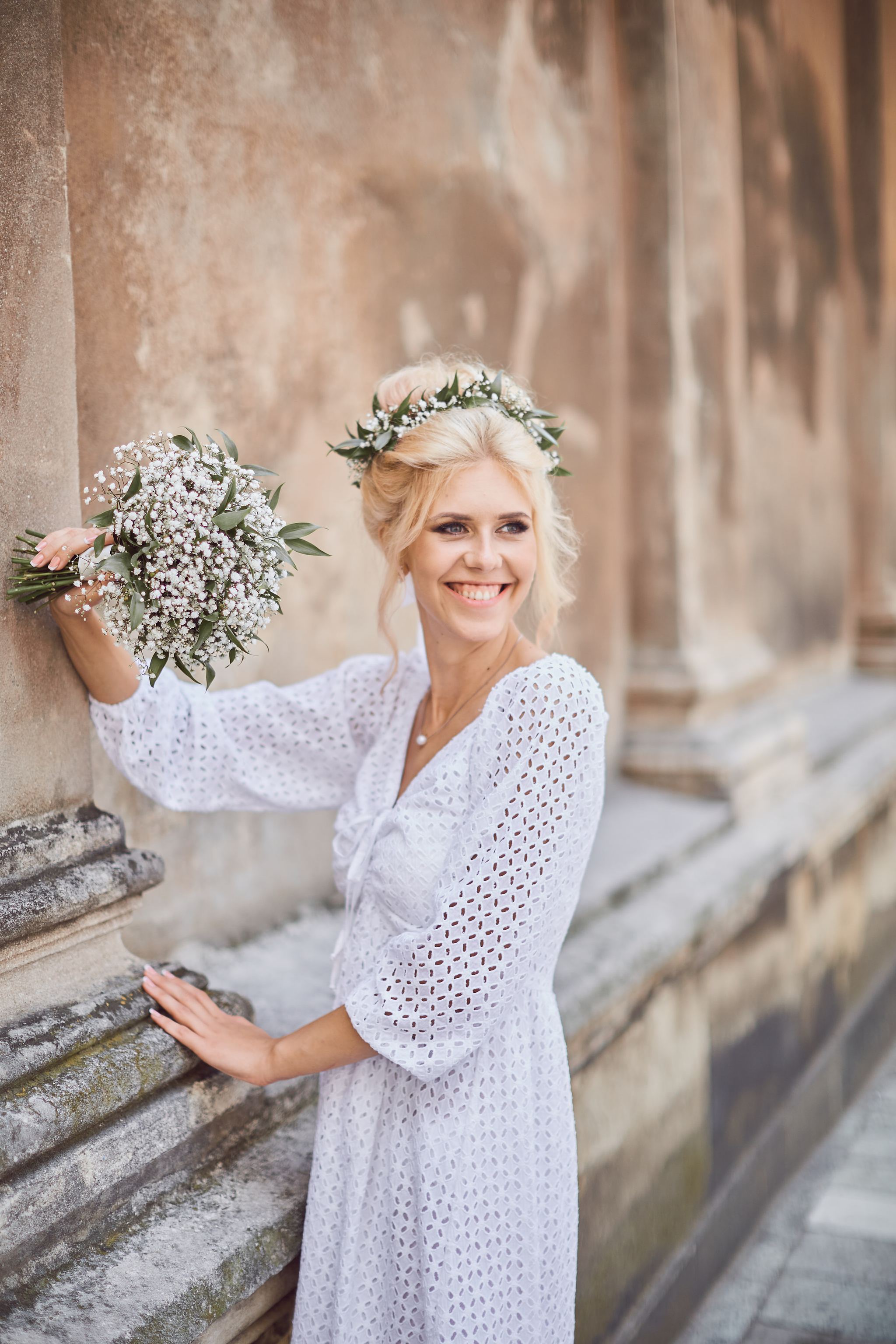 Smiling bride holding a delicate white flower bouquet
