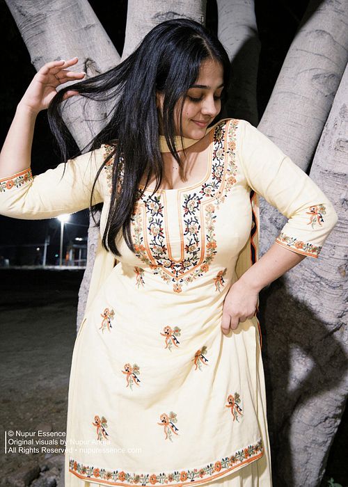 Yellow Punjabi suit portrait featuring Nupur Ahuja against a tree backdrop.