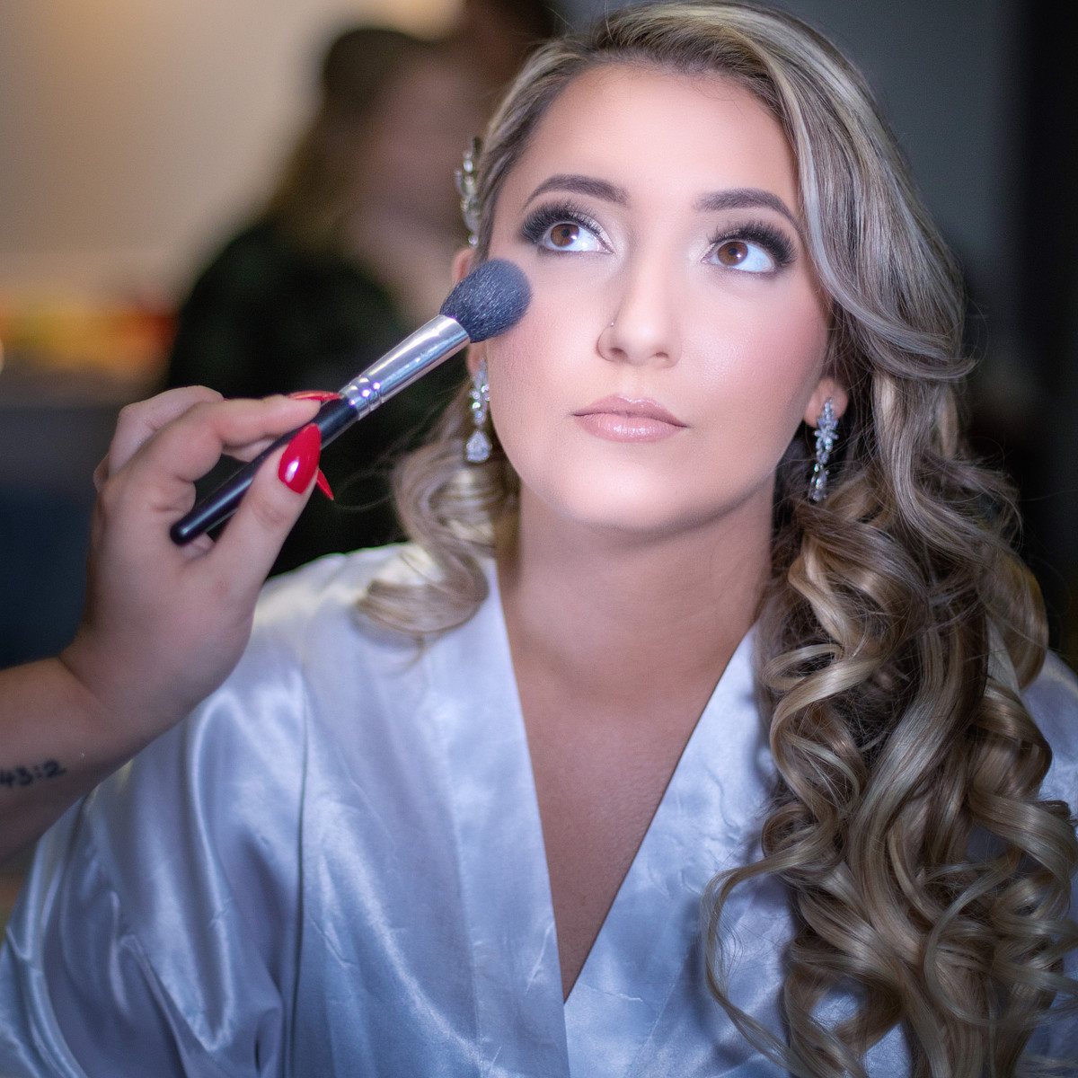 make-upartist adding finishing powder after finishing applying expert wedding make-up